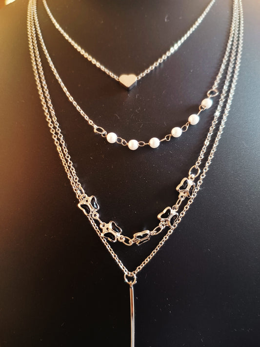A silver-plated three-layered butterfly-shaped necklace with pearl accents displayed on a chain.