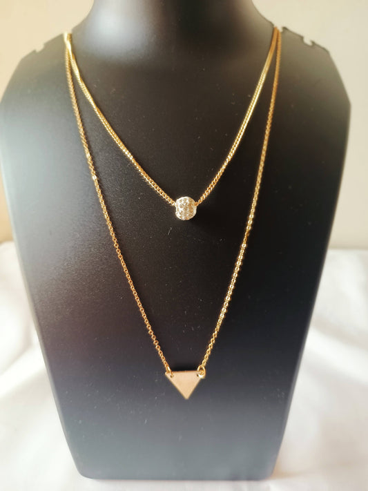 A gold-plated double-layered triangle neckpiece with a geometric design, displayed on a mannequin bust.