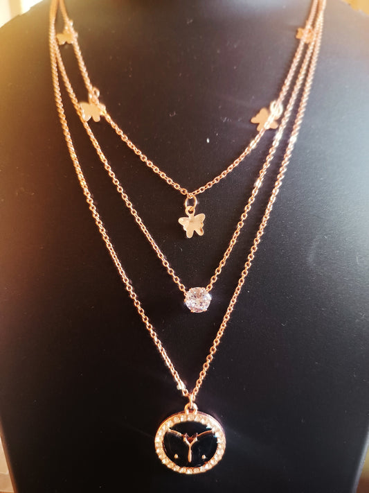 A rose-gold-plated three-layered black colored butterfly neckpiece displayed on a mannequin.