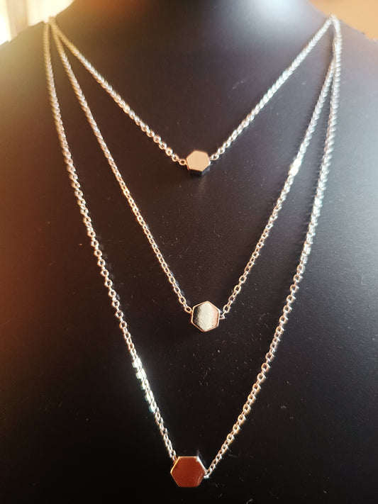 Three layered silver plated pentagon neckpiece displayed on a mannequin.