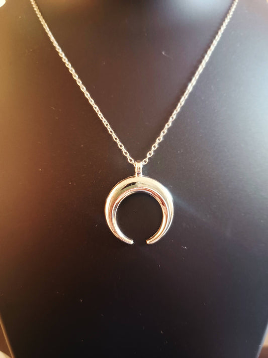 A silver-plated single chain moon neckpiece displayed on a mannequin.