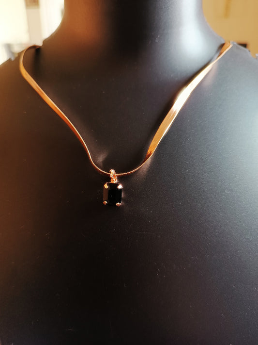 A gold-plated single-layered black diamond neckpiece displayed on a mannequin bust.