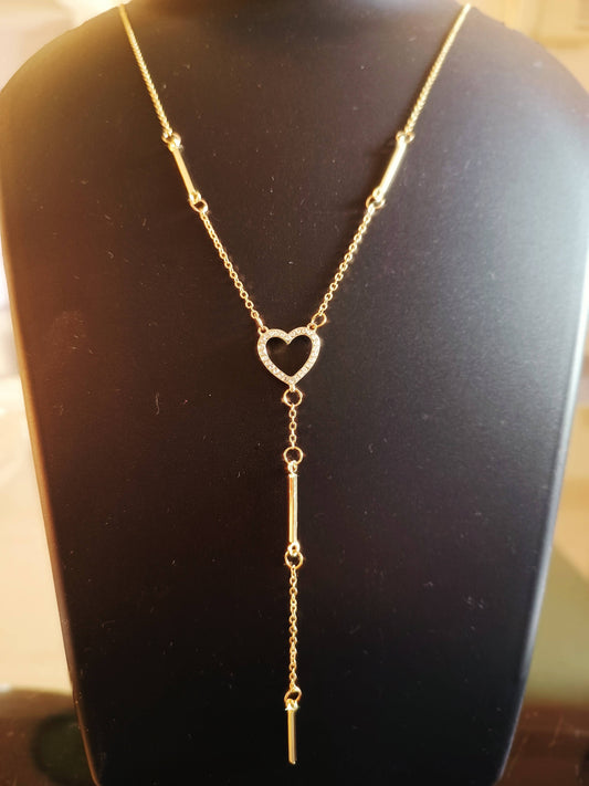 A gold-plated, single-layered long heart neckpiece with diamond studs displayed on a mannequin.