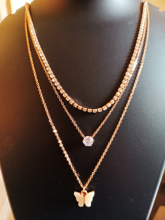 A rose-gold-plated three-layered diamond-studded beige colored butterfly neckpiece displayed on a mannequin.