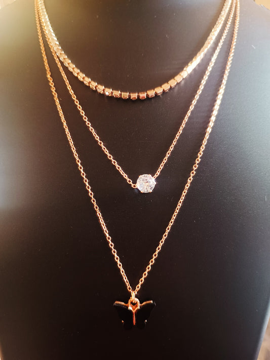A rose-gold plated, diamond-studded, three-layered black-colored butterfly neckpiece displayed on a mannequin.
