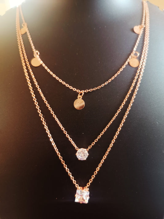 A three layered rose-gold plated diamond neckpiece with round and pearl-like embellishments.