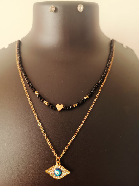 A gold-plated black beads double-layered neckpiece with a geometric evil-eye design, displayed on a mannequin bust.