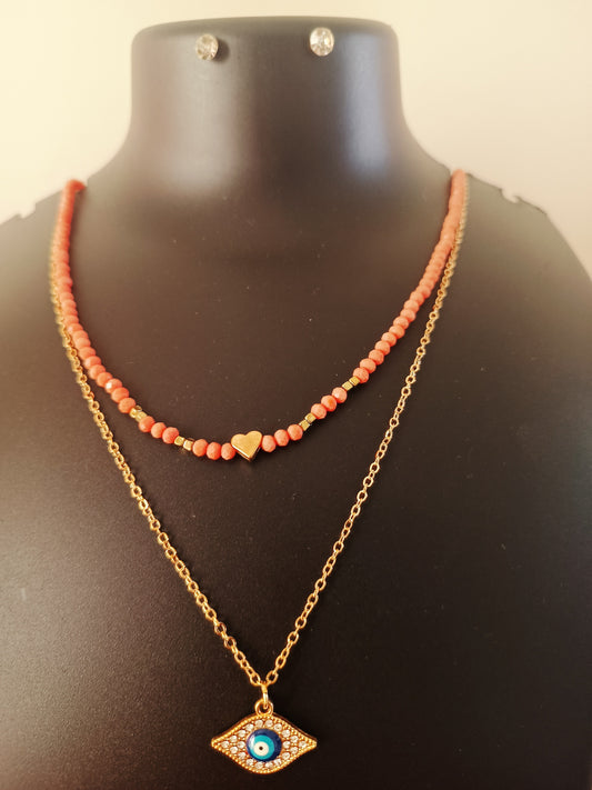 A gold-plated orange beads double-layered evil-eye neckpiece with earrings displayed on a mannequin.