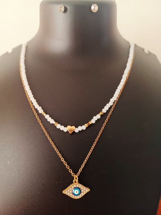 A gold-plated double-layered white beads neckpiece with earrings displayed on a mannequin bust.